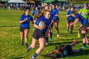 A female rugby player carrying the ball