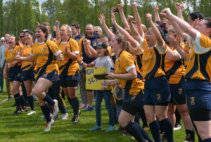 A female rugby team celebrates after winning a championship