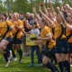 A female rugby team celebrates after winning a championship