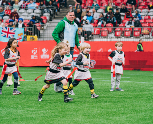A group of children play Rugby on the BC Place field