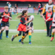 A group of children play Rugby on the BC Place field