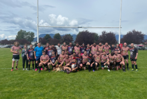 A group of Rugby players huddle under the posts for a team photo