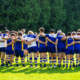 A rugby team huddles on the pitch before a match