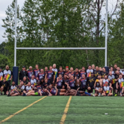 The Vancouver Rogues and Seattle Quake Rugby teams pose for a photo beneath the posts after a game