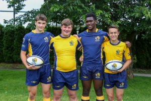 A group of four male players model the new navy and gold BC Bears kits