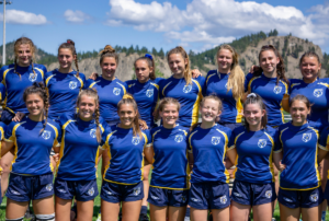 A group of girls dressed in blue BC Rugby jerseys pose for a photo