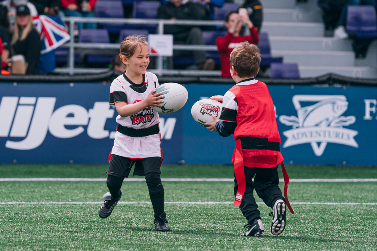 Two mini rugby players run during a session at Langford