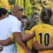 A Coach leads a pre-match huddle with a female Rugby team