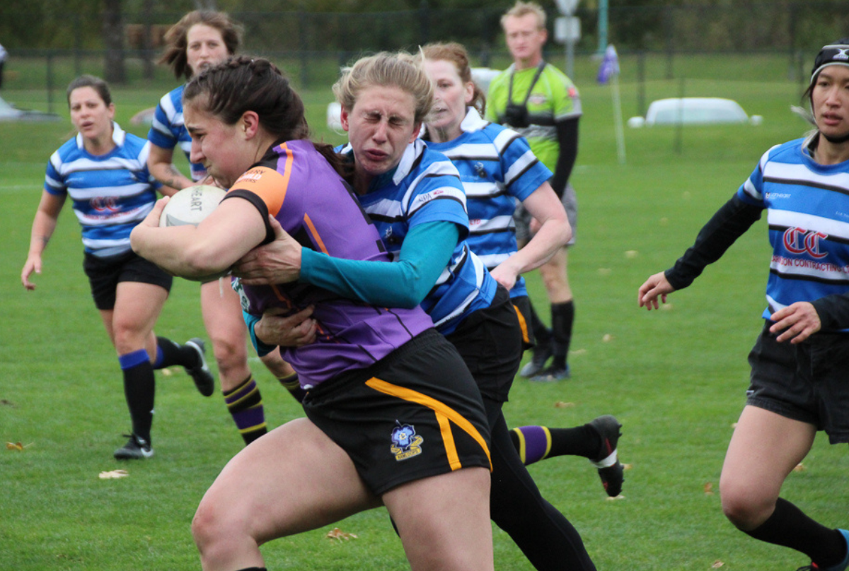 Two female Rugby players contest a ball during a match