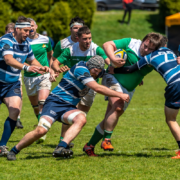 A Kats RFC Player runs with the ball as he is tackled by two Bayside Sharks players in the 2022 Men's Division 3 Final