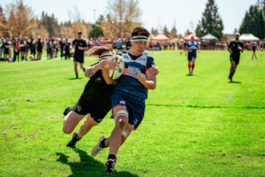 A Port Alberni player tackles a UBCOB Ravens player during the 2023 BC Rugby Senior Club Finals