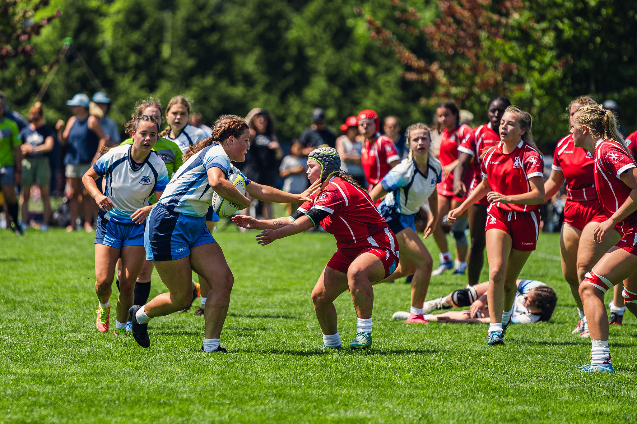 A girl runs with the rugby ball into a tackle at the 2023 provincial regional championships