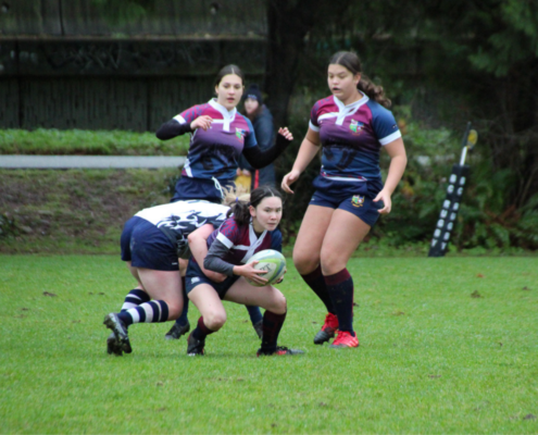 A United RFC Junior Girls player carries the ball through a tackle